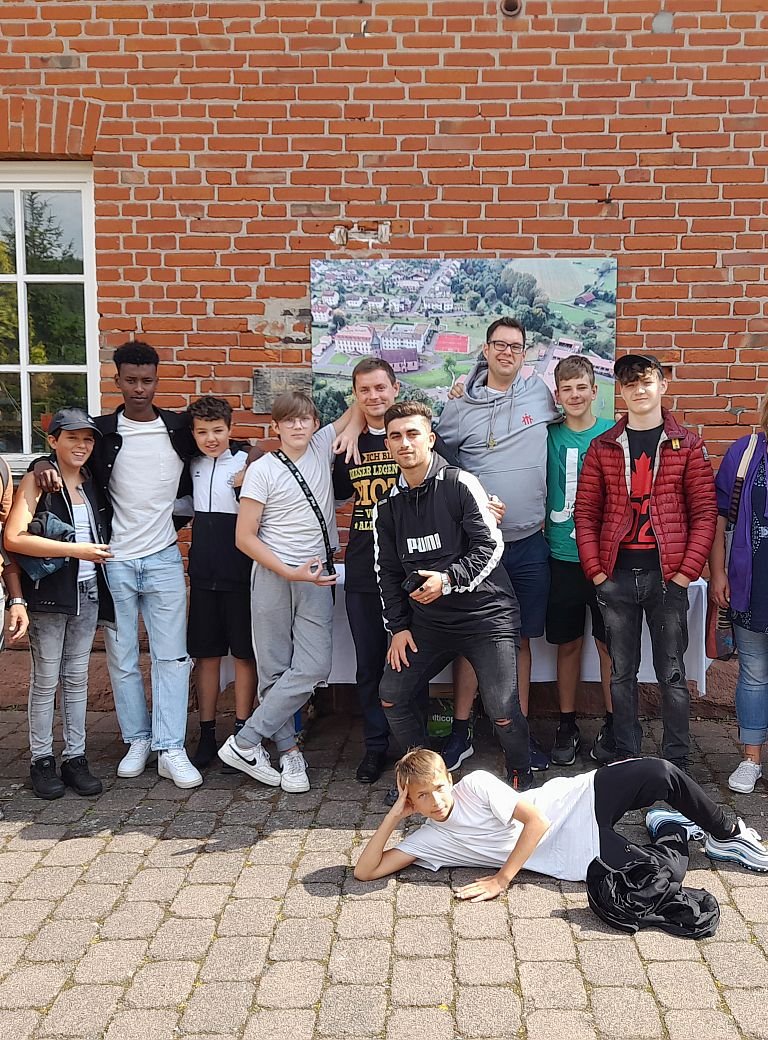 Gruppenbild Jugendliche mit Salesianer vor Backsteingebäude