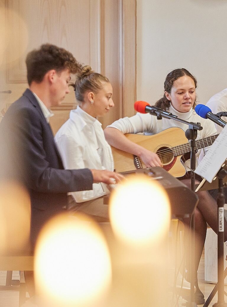 Jugendliche musizieren und singen bei Kerzenlicht beim Don Bosco Stifterfest in Benediktbeuern 