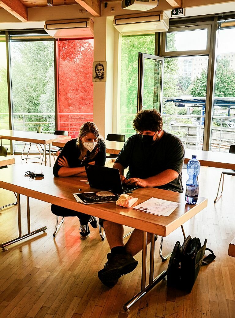 Jugendliche und Pädagogen arbeiten gemeinsam an Laptops in der Manege im Don-Bosco-Zentrum in Berlin  