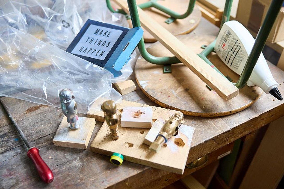 Bastelmaterialien und mit Gold- und Silberfarbe bemalte Tischkicker-Figuren