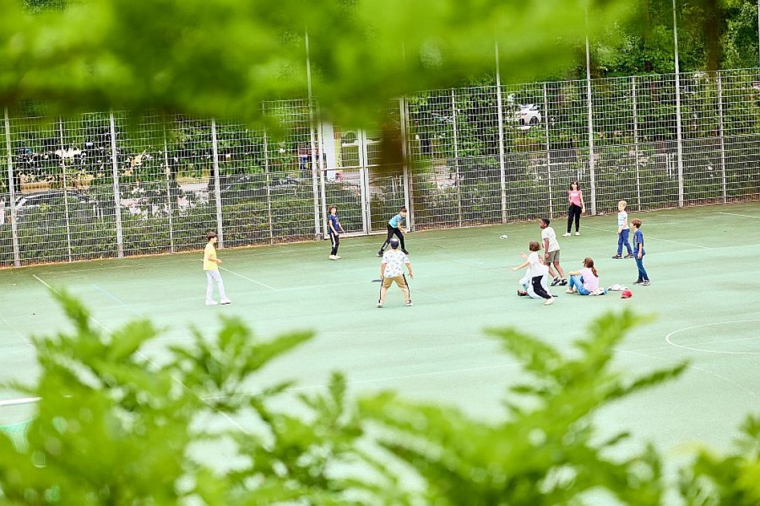 Kinder spielen auf grünem Sportplatz