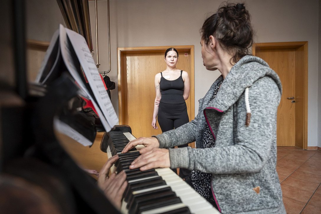 Jugendliche bei Einzelprobe, Frau spielt Klavier