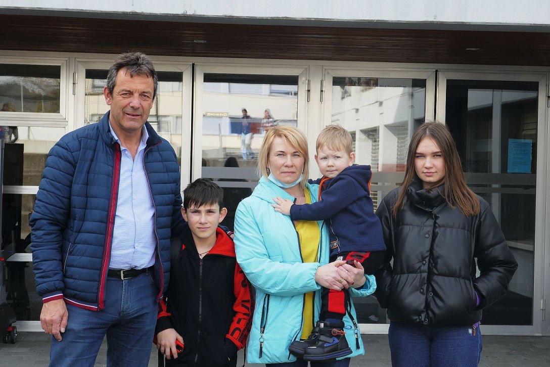 Markus Burri mit Mutter und drei Kindern vor dem Eingang eines Gebäudes 