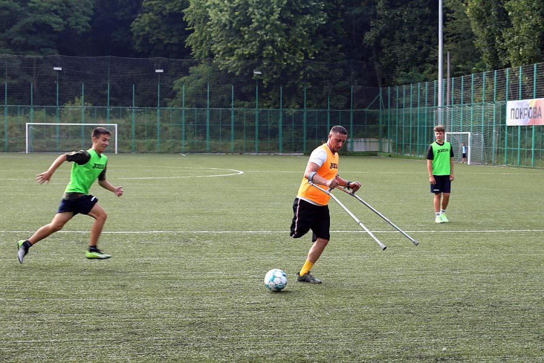 Männer bei Fußballtraining bei Don Bosco in Lemberg, darunter auch ein Mann mit amputiertem Bein und Krücken 
