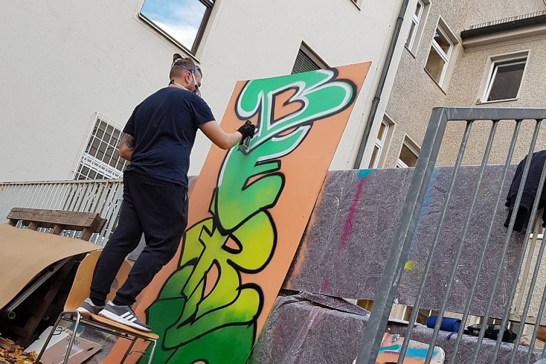 Junger Mann verziert Wand an Münchner Salesianum mit Graffiti 