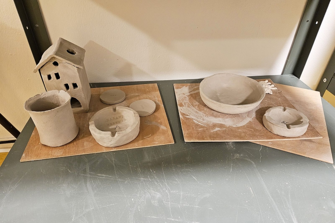 Selbstgemachte Objekte wie Haus, Vase, Schüsseln und Aschenbecher aus Ton
