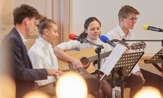 Jugendliche musizieren und singen bei Kerzenlicht beim Don Bosco Stifterfest in Benediktbeuern 