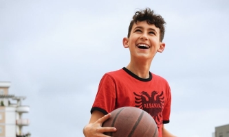Junge mit Ball bei Sportprogramm im Don Bosco Sozialzentrum in Tirana